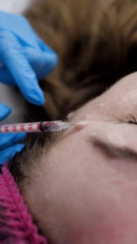 Injection Botox Needle Syringe under the Woman Face Skin, tightening Procedure.