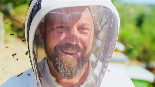 Some bees flying around the face of a beekeeper wearing protective gear in a field
