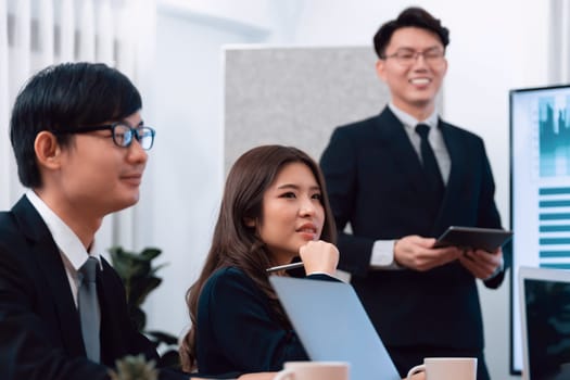 Confidence and asian businessman give presentation on financial analyzed by business intelligence in dashboard report to other people in board room meeting to promote harmony in workplace.