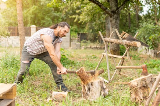 Strong male woodcutter chopping a log on a garden