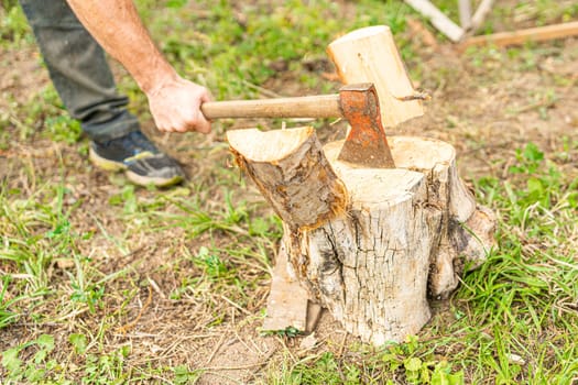 High angle view of a man cutting wood with an axe in a garden