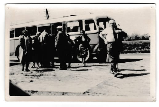 THE CZECHOSLOVAK SOCIALIST REPUBLIC - CIRCA 1950s: Retro photo shows tourists in front of the bus. Vintage black and white photography.