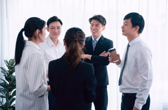 Mentor, manager with coffee advice younger colleagues in workplace. Businesspeople discussing or planning financial project strategy, talking together for harmony and strong teamwork in office concept