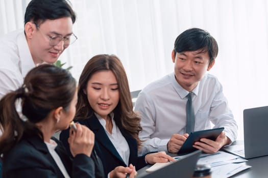 Harmony in office concept as business people analyzing dashboard paper together in workplace. Young colleagues give ideas at manager desk for discussion or strategy planning about project.