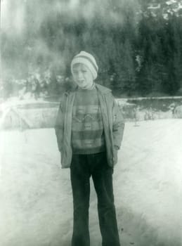 THE CZECHOSLOVAK SOCIALIST REPUBLIC - CIRCA 1980s: Retro photo shows a young boy in winter time. Vintage black and white photography.