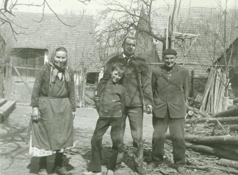 THE CZECHOSLOVAK SOCIALIST REPUBLIC - 1968: Retro photo shows rural people stand in the backyard. Vintage black and white photography.