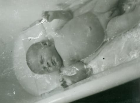 THE CZECHOSLOVAK SOCIALIST REPUBLIC - 1959: Retro photo shows newborn baby. Vintage black and white photography. Note: blurriness, better at smaller sizes.