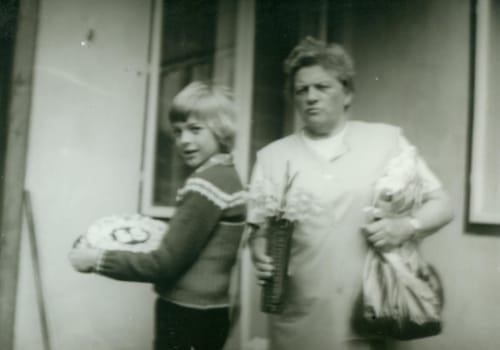 THE CZECHOSLOVAK SOCIALIST REPUBLIC - 1959: Retro photo shows mother and her son in the backyard. Vintage black and white photography. Note: blurriness, better at smaller sizes.