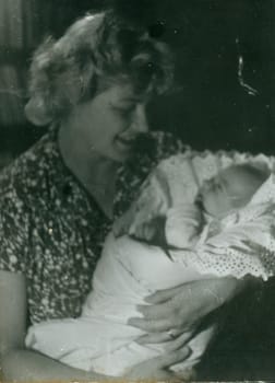 THE CZECHOSLOVAK SOCIALIST REPUBLIC - CIRCA 1960s: Retro photo shows woman cradles newborn baby. Vintage black and white photography.