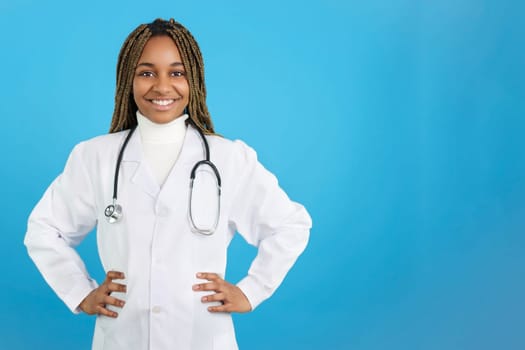 Studio portrait with blue background of a african female doctor smiling at the camera