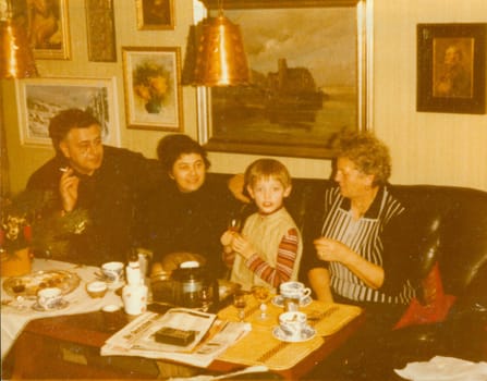 THE CZECHOSLOVAK SOCIALIST REPUBLIC - CIRCA 1980s: Retro photo shows family during small home party in the living room. Vintage color photography.