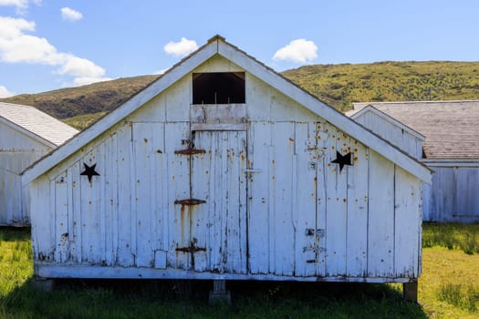 Rustic wooden storage shed painted white on historic Pierce Point Ranch. High quality photo