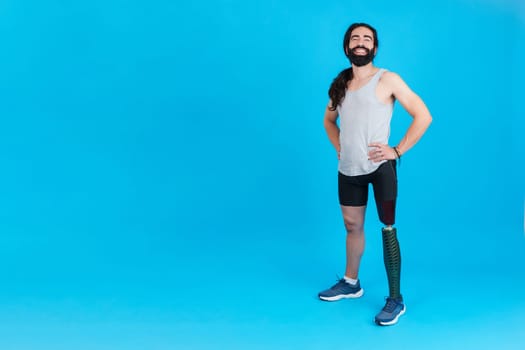 Studio portrait with blue background and copy space of a proud man standing with a leg prosthesis