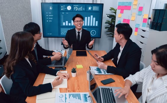 Confidence and asian businessman give presentation on financial analyzed by business intelligence in dashboard report to other people in board room meeting to promote harmony in workplace.