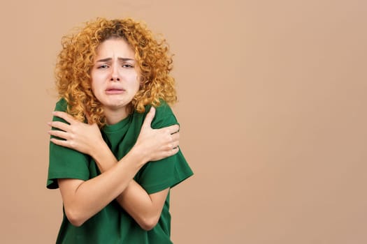 Studio image of a woman who is very cold on brown background