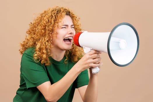 Studio image of a woman with curly hair angry shouting over a loudspeaker