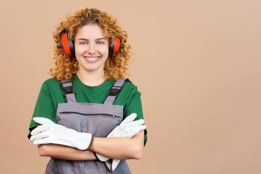 Studio image of a smiley woman carpentry worker with tools and work uniform