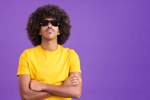 African man in cocky pose looking at camera with sunglasses on in studio
