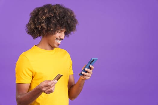 African man using a card to shopping online with the mobile in studio