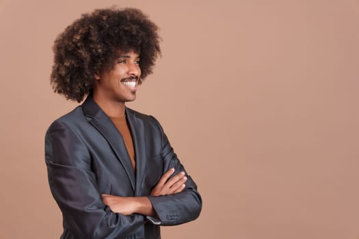 Smiley stylish african man with a black jacket crossing the arms in studio