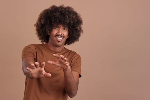 African man with curly hair gesturing with the hands in fear in studio