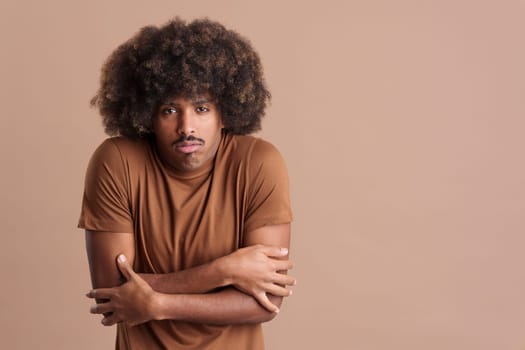 African man with curly hair looking at the camera in the cold in studio