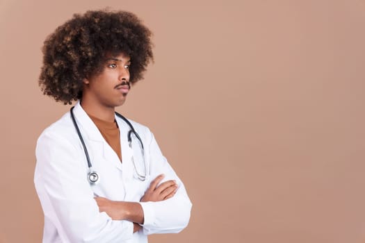 Serious african doctor with arms crossed looking aisde in studio