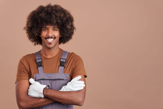 Friendly african man carpentry worker looking at the camera wearing a work uniform in studio