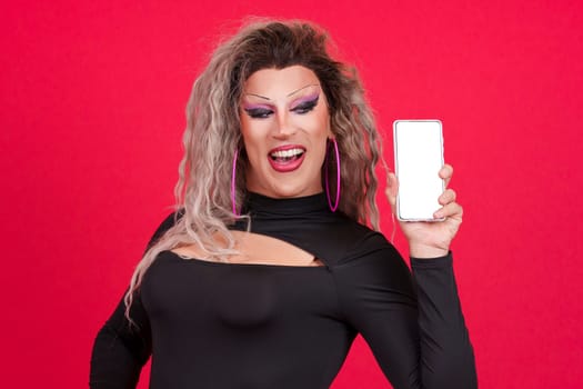 Blank screen of the mobile held by a transgender person dressed as drag queen in studio with red background