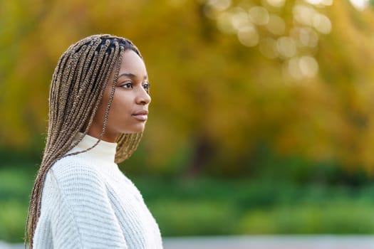 Photo with copy space of a serious african woman looking up in a park