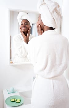Skincare, face and cosmetic cream of an African woman using facial beauty products for morning self care. Female with a smile health and wellness in a home bathroom.