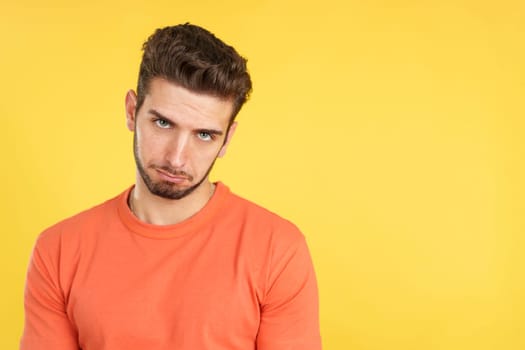 Caucasian man making a pity face to ask for something in studio with yellow background