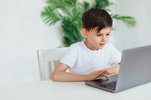 an education online online games boy sits at the computer in the office