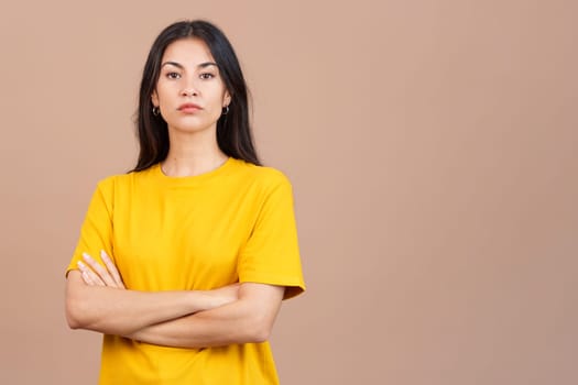 Caucasian woman crossing the arms with an angry expression in studio with brown background