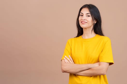 Beauty hispanic woman standing whit arms crossed smiling at the camera in studio with brown background