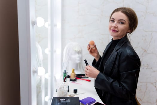 Portrait of a beauty woman looking at camera while making up in a backstage