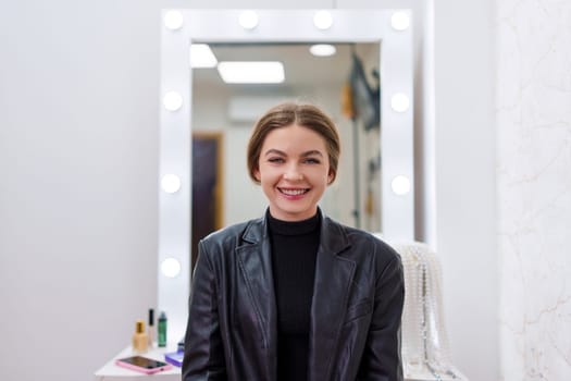 Portrait of a woman smiling at camera with make-up in a dressing room