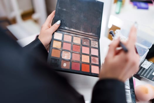 Close up photo of an unrecognizable woman with a make-up palette with different mascara shades