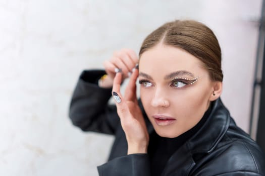 Concentrated caucasian beauty woman applying instant invisible stickers to the face on a backstage