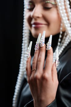 Vertical portrait with focus on the hand of a woman with white fake nail extensions