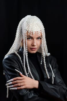 Vertical studio portrait of a cool woman with a wig of pearls and make up