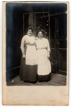 THE CZECHOSLOVAK REPUBLIC - CIRCA 1930s: Vintage photo shows two housekeepers pose outside - in the backyard. Retro black and white photography.