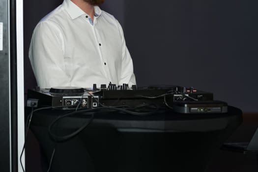 DJ in a white shirt and his equipment at a wedding