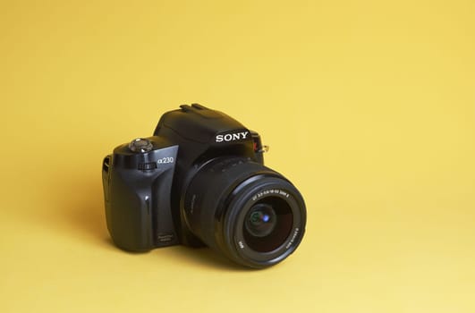 Seversk Russia, March 2023, the body of the Sony A65 Sony alpha full-frame mirrorless camera . Black body of the SLR camera on a yellow background