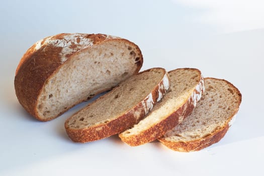 A loaf of bread highlighted on a white background. View from above. He was lying flat. Creative bread layout Sliced bread on a white background. Slices of bread, top view.