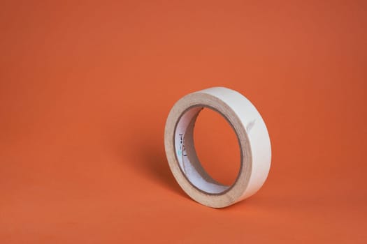 Extreme close-up image of a roll of adhesive tape on a brown background