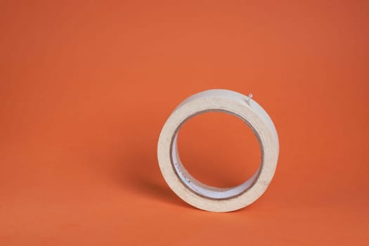 Extreme close-up image of a roll of adhesive tape on a brown background