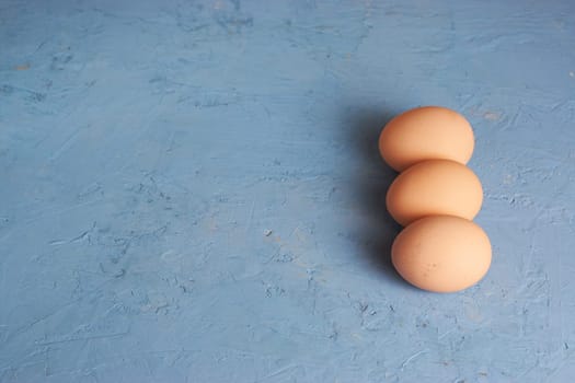 Three red Easter eggs on a blue background. Colorful decoration of Easter eggs. Flat position, top view. with a place to copy the text. Minimal idea for an Easter concept.