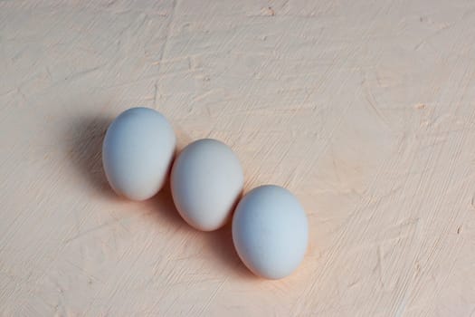 Three red Easter white eggs on a light background. Colorful decoration of Easter eggs. Flat position, top view. with a place to copy the text. Minimal idea for an Easter concept.