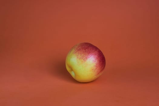 Red-yellow apple on a brown background red apple on a dark brown background